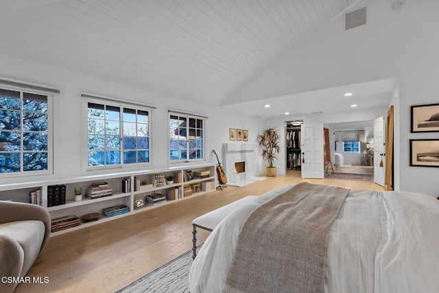 bedroom with wood ceiling, high vaulted ceiling, and light hardwood / wood-style floors