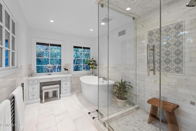 bathroom featuring tile patterned flooring, shower with separate bathtub, tile walls, and vanity