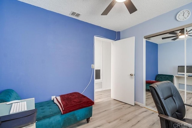 office area with ceiling fan, light hardwood / wood-style floors, and a textured ceiling