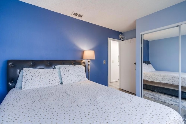 bedroom featuring hardwood / wood-style flooring, a closet, and a textured ceiling