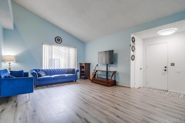 living room with lofted ceiling, a textured ceiling, and light wood-type flooring