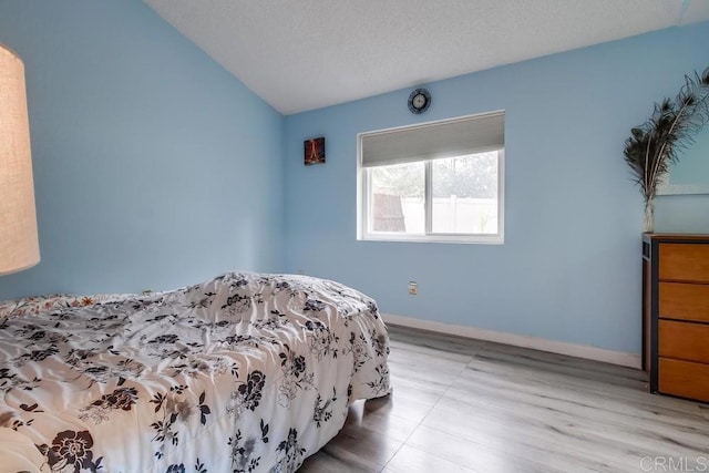 bedroom with lofted ceiling and a textured ceiling