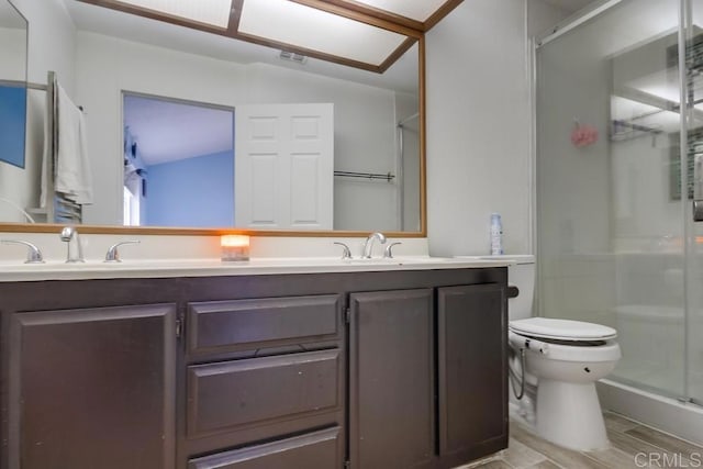 bathroom featuring vanity, a shower with shower door, and toilet