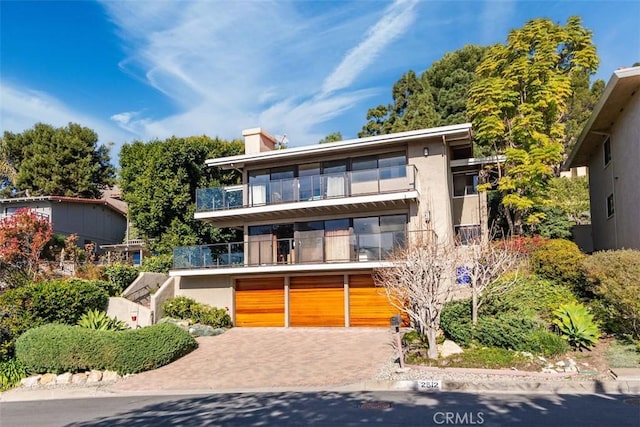 view of front of home with a garage and a balcony