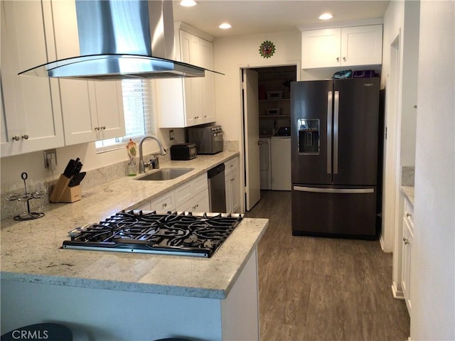 kitchen featuring sink, white cabinetry, ventilation hood, washer and dryer, and appliances with stainless steel finishes