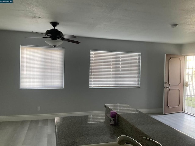 interior space with hardwood / wood-style flooring, ceiling fan, and a textured ceiling