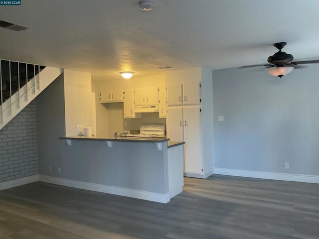 kitchen with white range with electric cooktop, white cabinetry, ceiling fan, kitchen peninsula, and dark wood-type flooring