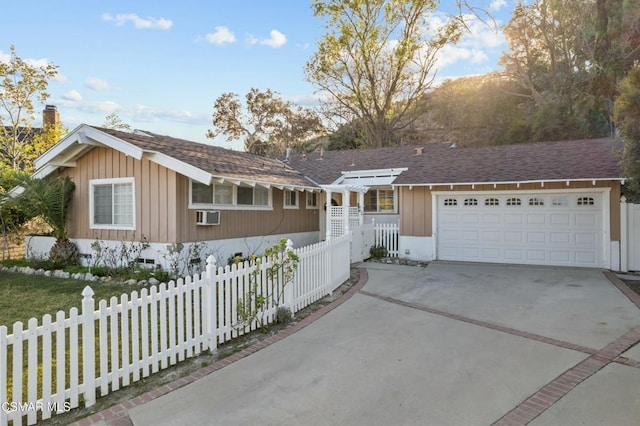 single story home with a garage and a wall mounted AC