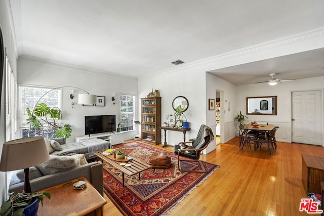 living room with crown molding, ceiling fan, and light hardwood / wood-style floors