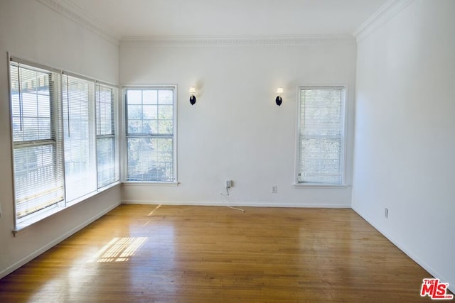 unfurnished room featuring ornamental molding and hardwood / wood-style floors