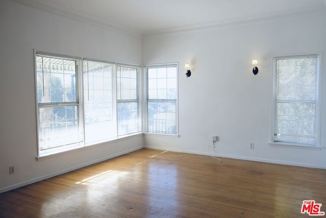 spare room with crown molding and hardwood / wood-style floors