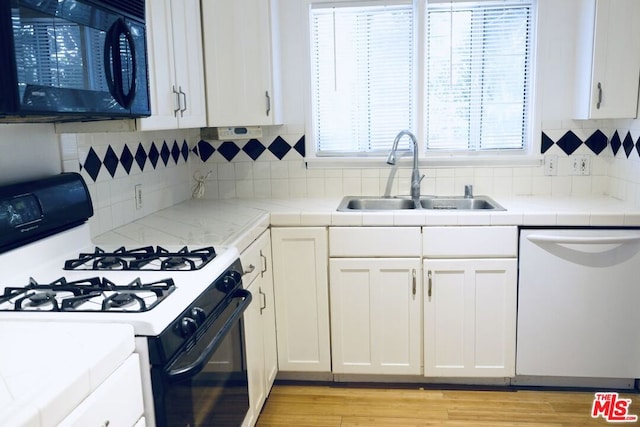 kitchen with sink, dishwasher, white cabinetry, tasteful backsplash, and range with gas stovetop