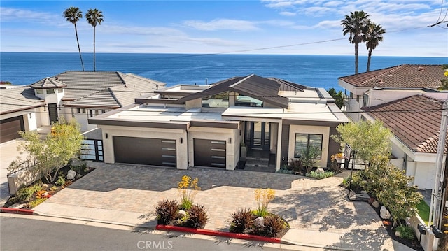 view of front of home with a garage and a water view