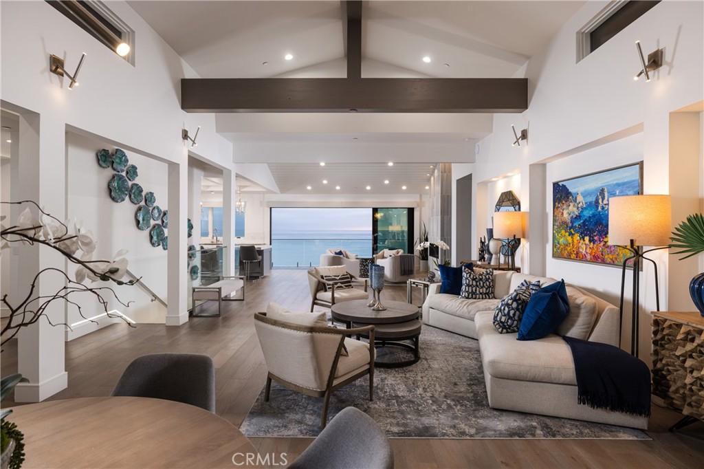 living room with beam ceiling, dark hardwood / wood-style flooring, and high vaulted ceiling