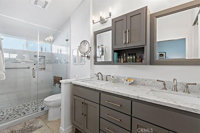 bathroom with vanity, a shower with shower door, tile patterned floors, and toilet