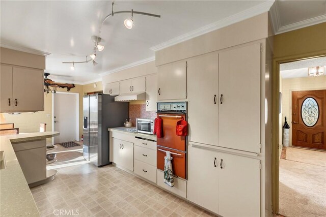 kitchen featuring crown molding, appliances with stainless steel finishes, and rail lighting