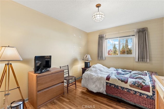 bedroom with hardwood / wood-style flooring and a textured ceiling