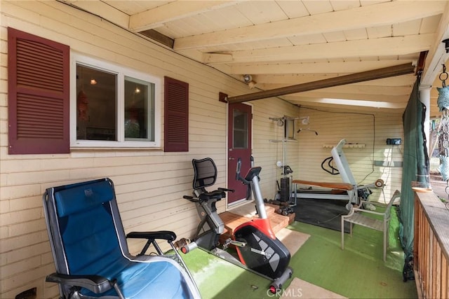 workout area with wood ceiling, lofted ceiling, and wood walls