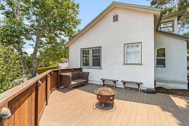 deck featuring an outdoor living space with a fire pit