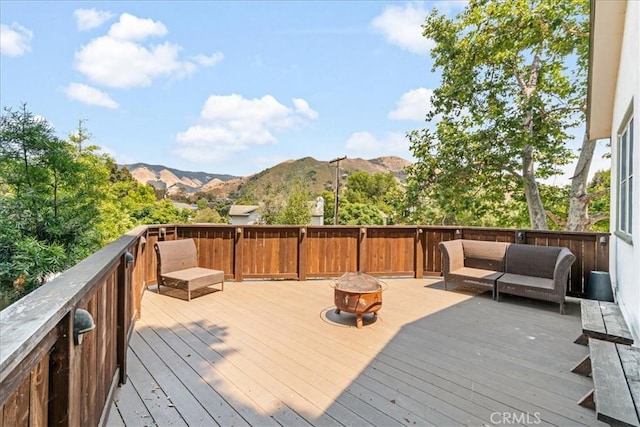 deck with a mountain view and an outdoor living space with a fire pit