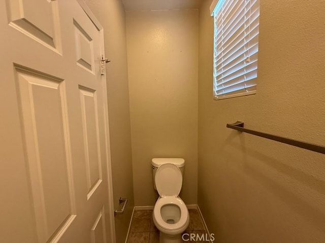 bathroom featuring toilet and tile patterned flooring