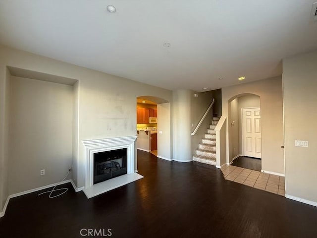 unfurnished living room with dark wood-type flooring