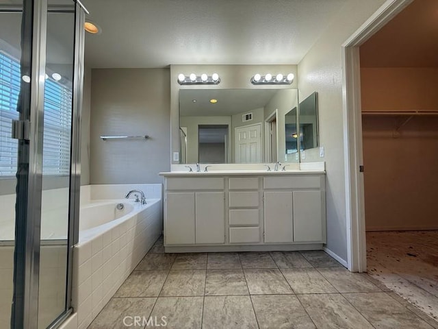 bathroom with tile patterned flooring, plus walk in shower, and vanity