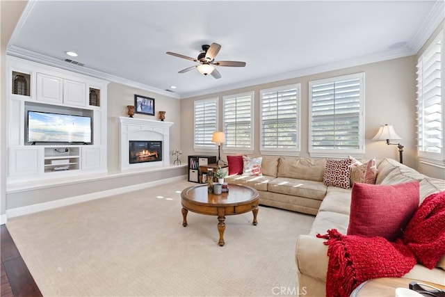 living room with ornamental molding, light wood-type flooring, and ceiling fan