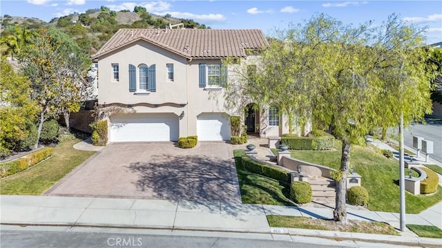 mediterranean / spanish-style house featuring a garage and a front yard