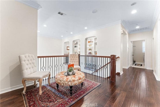 living area featuring built in shelves, ornamental molding, and dark hardwood / wood-style flooring