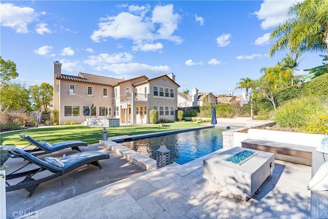 view of swimming pool with a patio, a lawn, and an outdoor fire pit