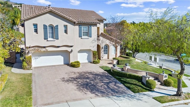 mediterranean / spanish house featuring a garage and a front yard