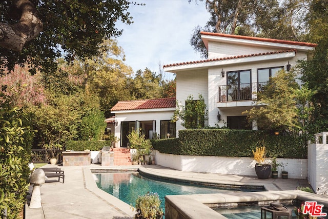 back of house featuring a fenced in pool and a patio