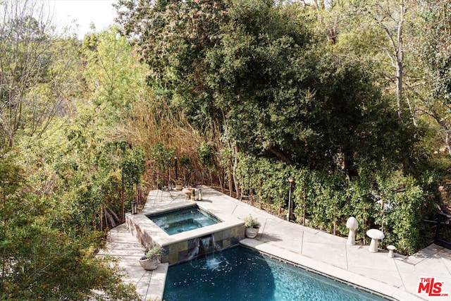 view of pool featuring an in ground hot tub, pool water feature, and a patio area