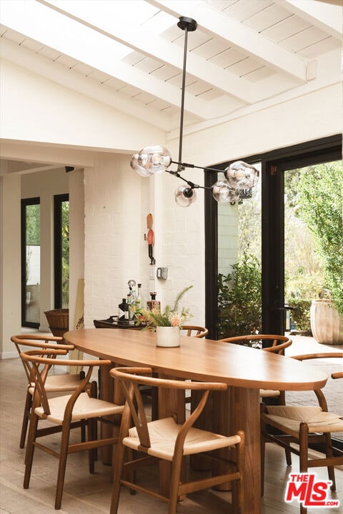 dining area featuring hardwood / wood-style floors, wood ceiling, and lofted ceiling with beams