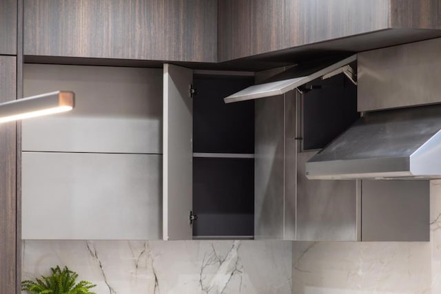 interior space featuring wall chimney exhaust hood and backsplash