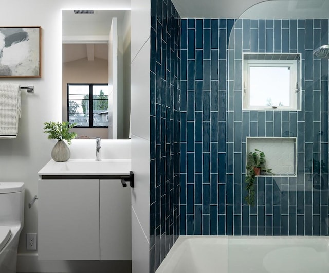 full bathroom featuring vanity, lofted ceiling, bathtub / shower combination, and toilet