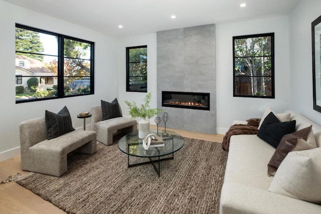 living room with hardwood / wood-style flooring and a tiled fireplace