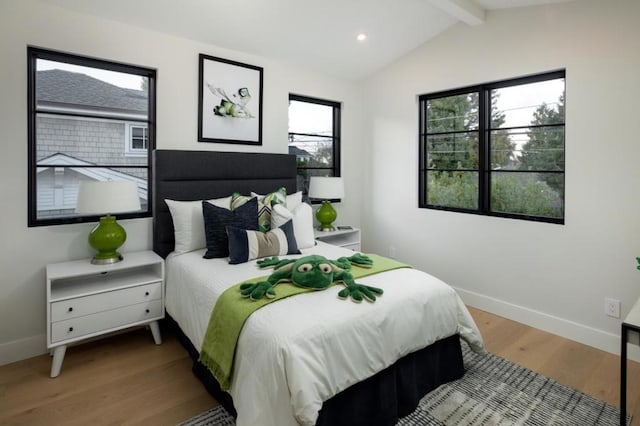 bedroom featuring hardwood / wood-style flooring and vaulted ceiling with beams