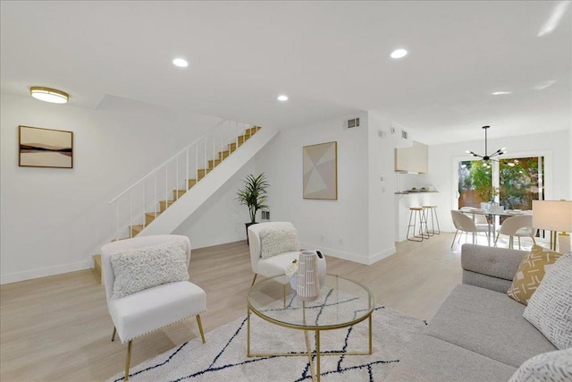 living room featuring a chandelier and light hardwood / wood-style floors