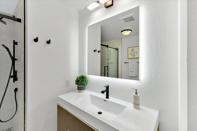 bathroom featuring vanity and a shower with shower door