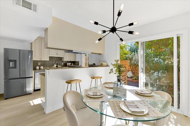 dining area featuring light hardwood / wood-style floors and a notable chandelier