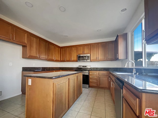 kitchen featuring stainless steel appliances, light tile patterned flooring, a center island, and sink