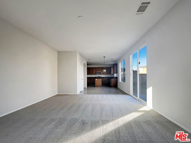 unfurnished living room featuring light colored carpet