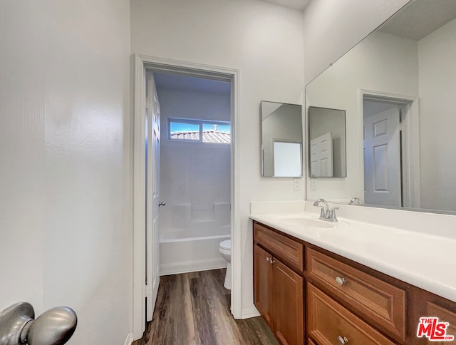 full bathroom featuring hardwood / wood-style flooring, vanity, toilet, and shower / washtub combination