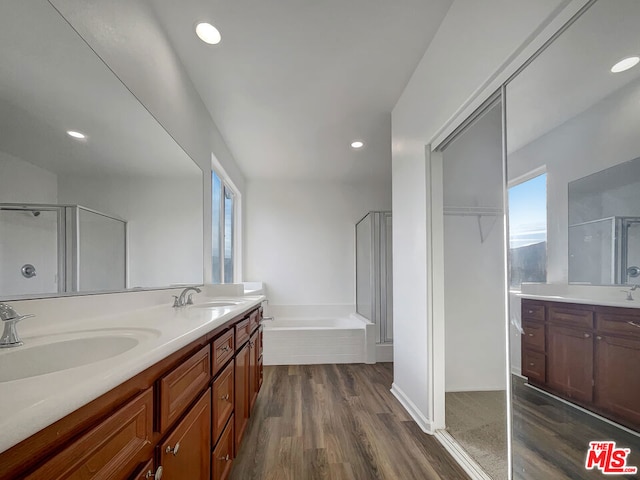 bathroom with vanity, shower with separate bathtub, and hardwood / wood-style floors