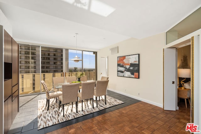 dining area with dark parquet floors and a wall of windows