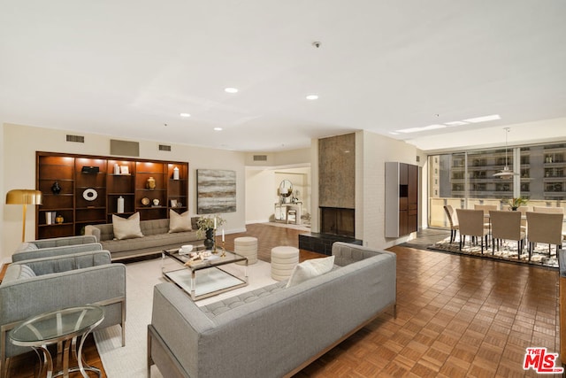 living room featuring parquet floors and a large fireplace