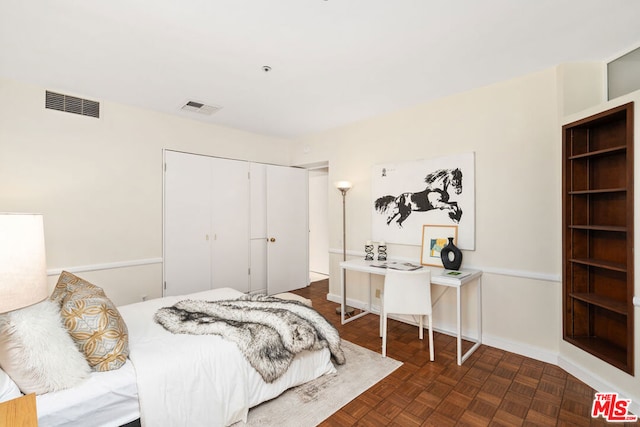 bedroom featuring dark parquet floors and a closet