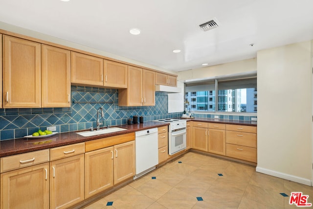 kitchen with sink, white appliances, light tile patterned floors, light brown cabinetry, and decorative backsplash